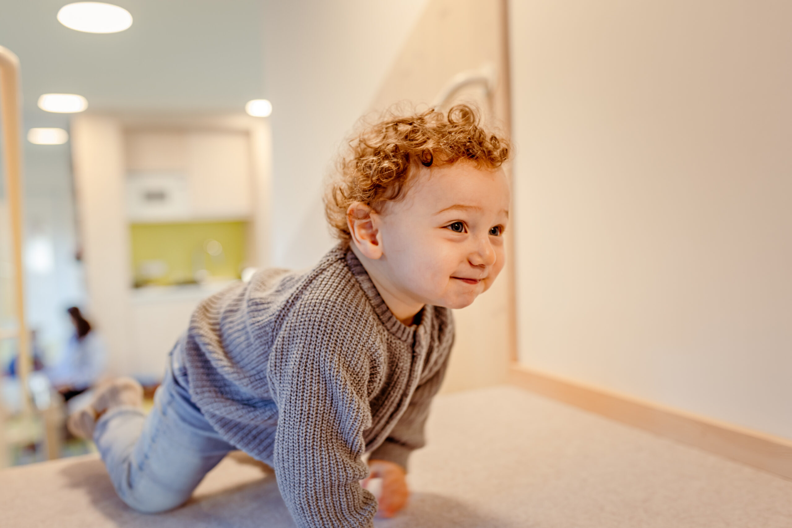 Ein Kind kriecht über den Boden in der Kinderkrippe Solln.